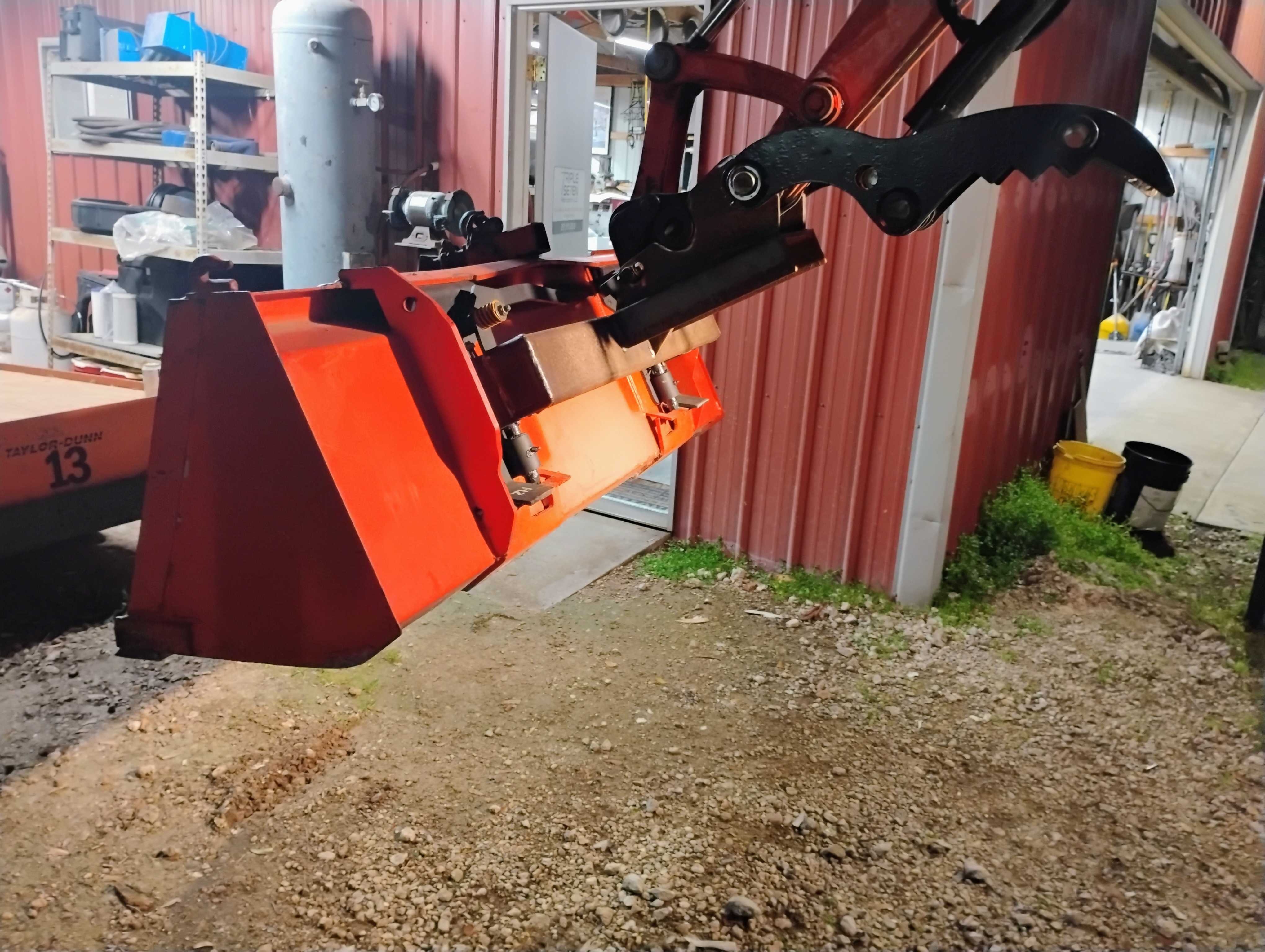 Red painted brush cutter attachment shown at an angle while mounted