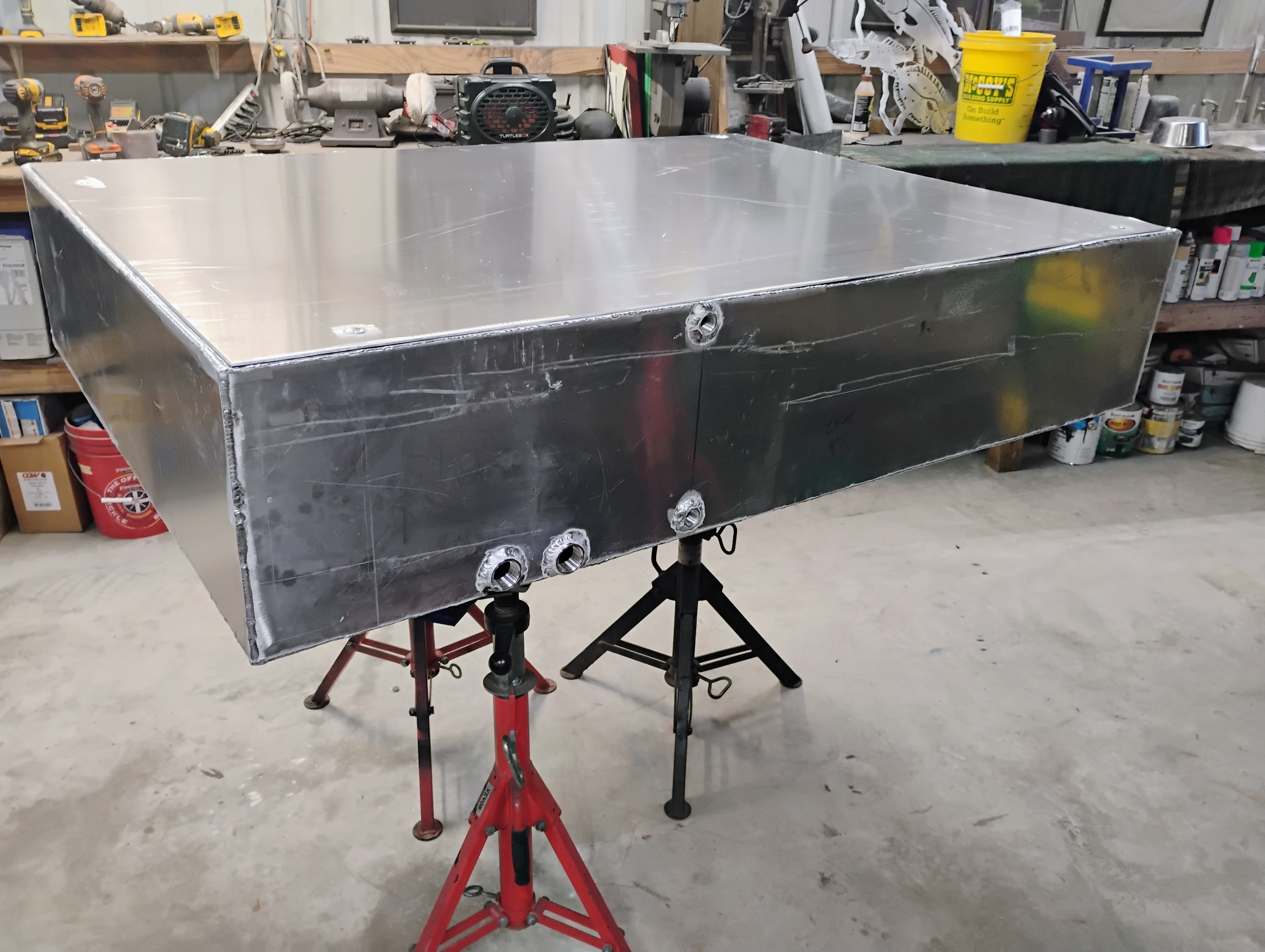 Port side view of custom stainless tank with threaded fittings and weld points