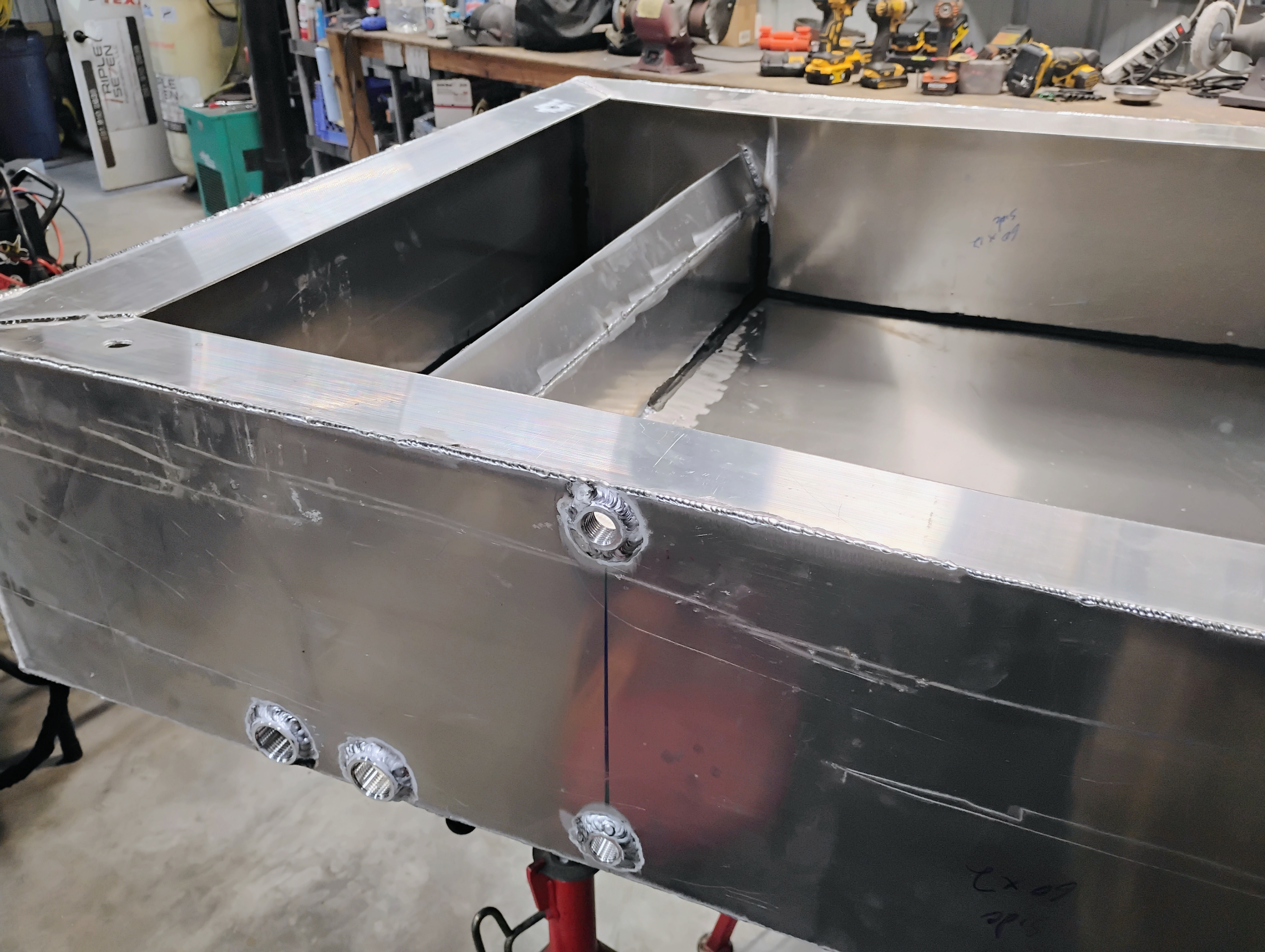Closeup of welds and fittings on custom stainless rectangular tank