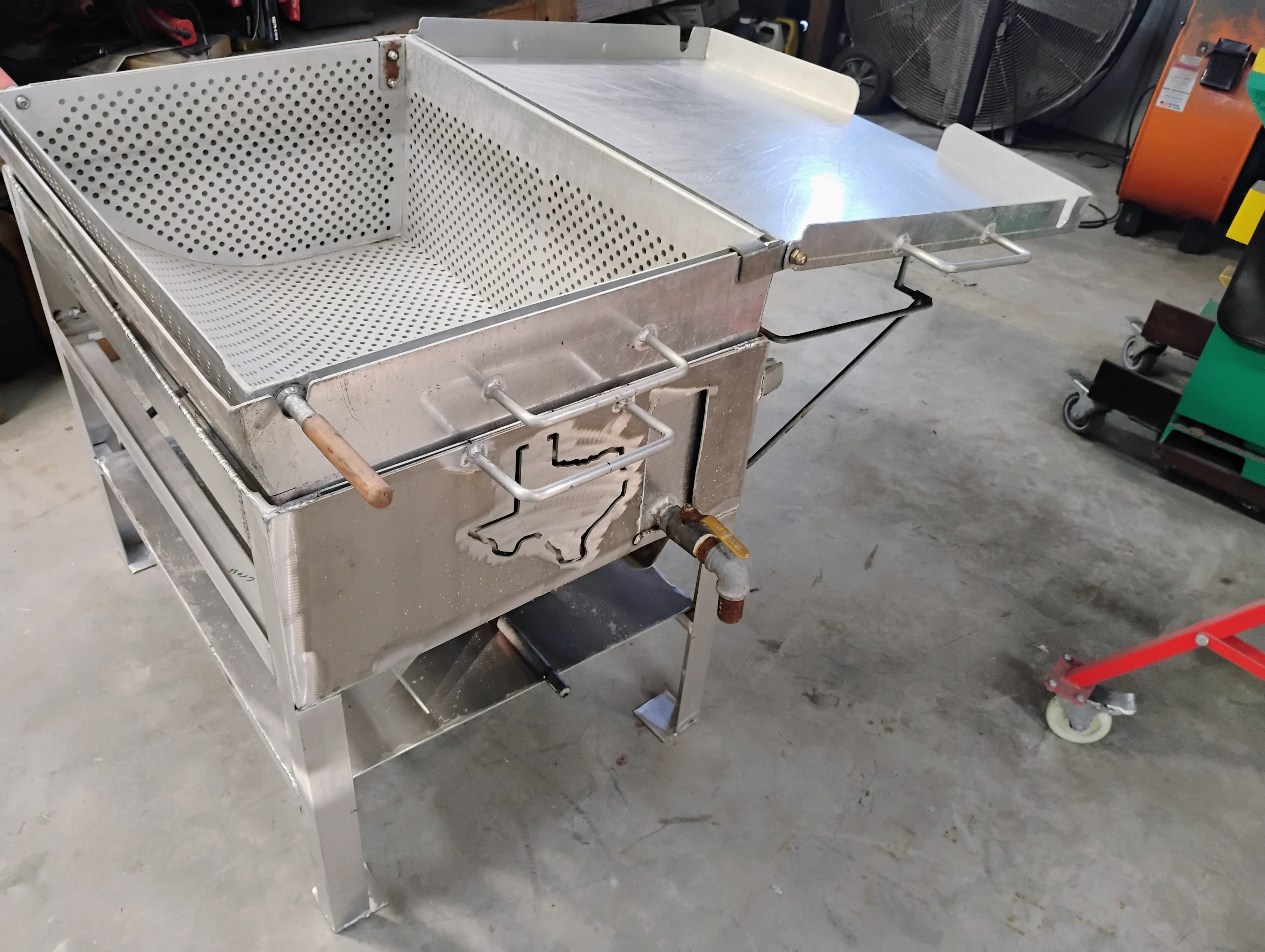 Custom stainless cooker with lid open showing perforated grate insert