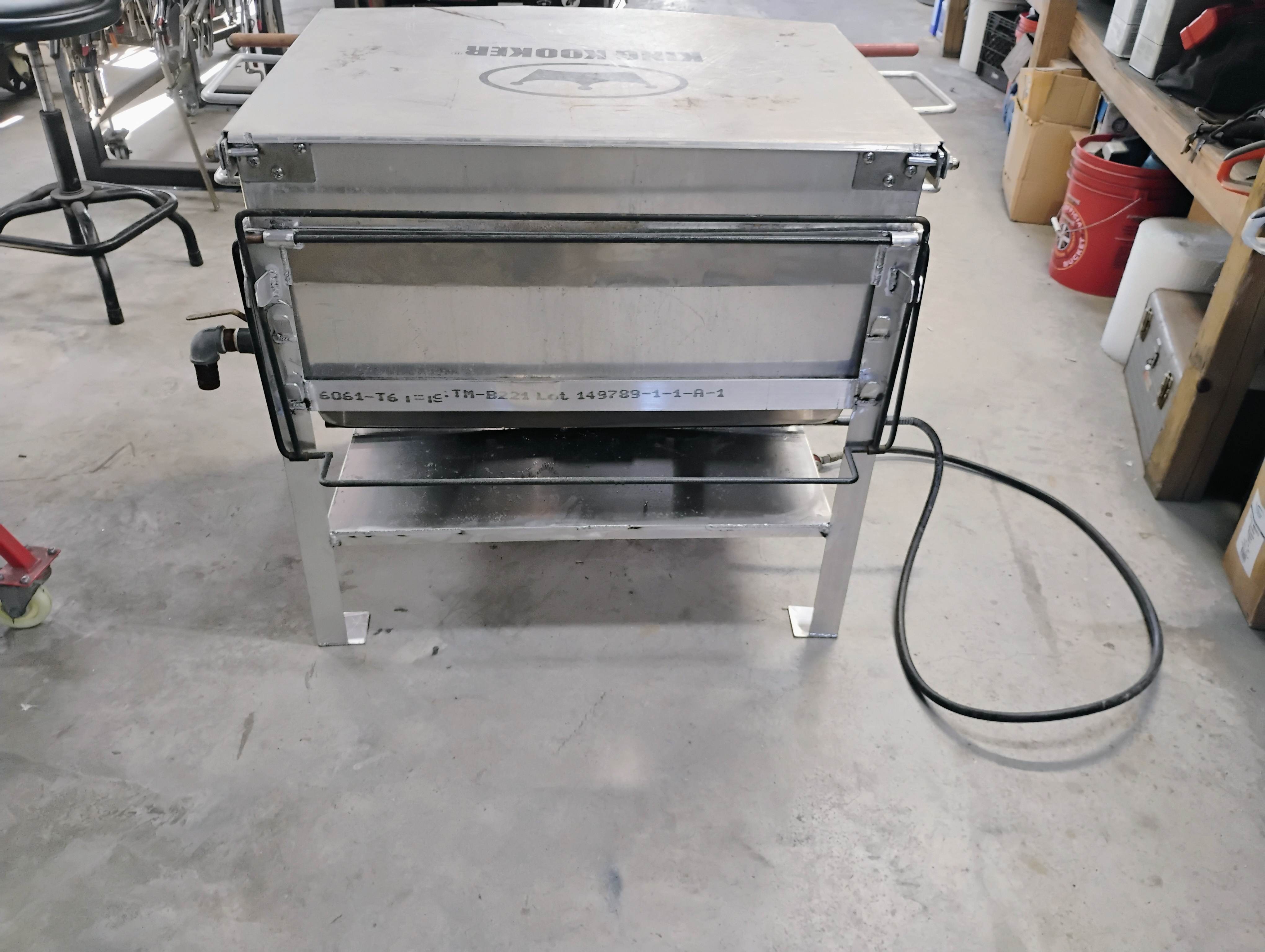 Rear view of custom stainless cooker showing frame and utility connection points