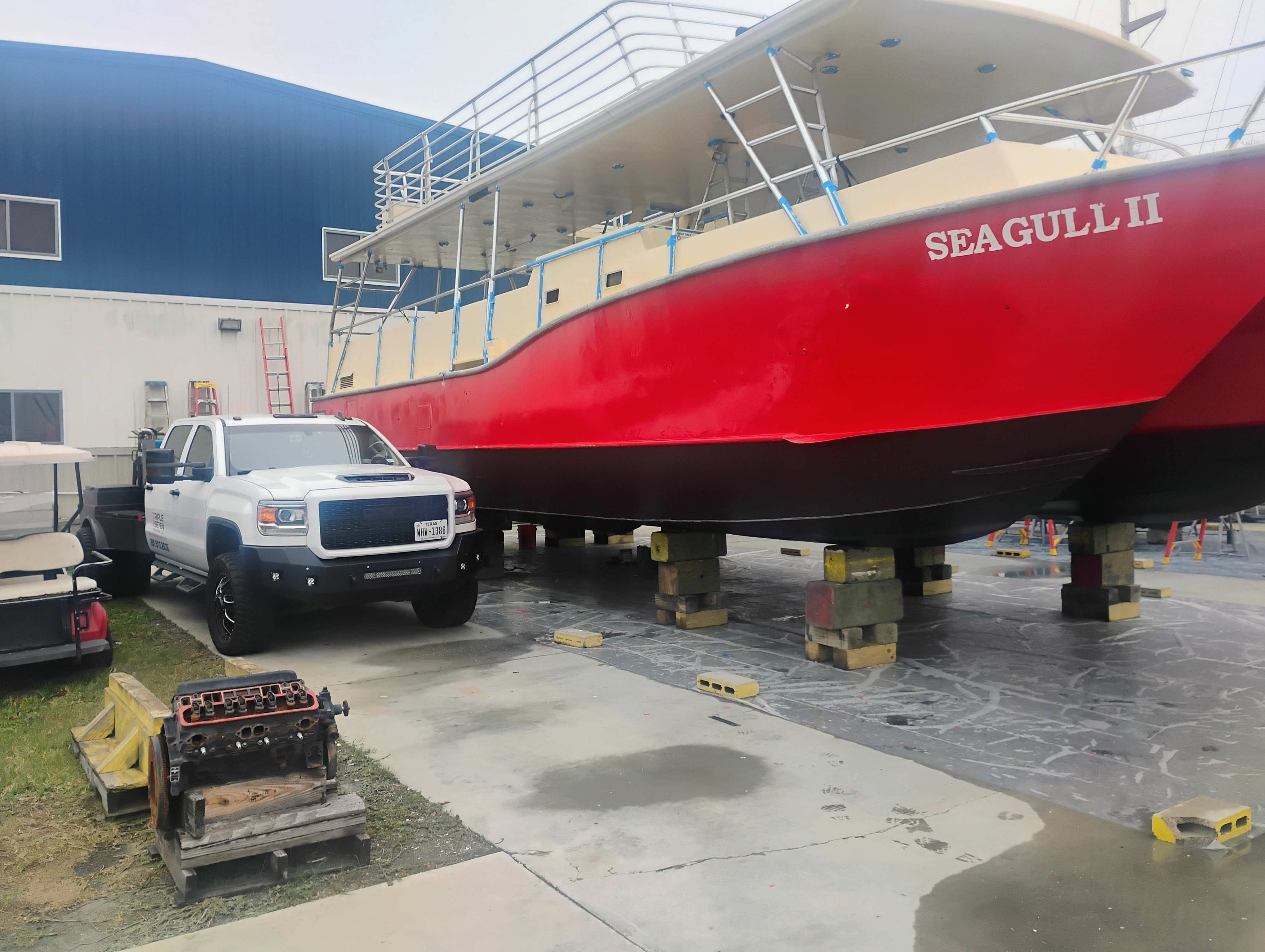 Boat hull repair with welding truck on site